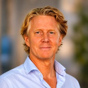Mats Johard Tieto, blond, ljus hudfärg och ljusblå skjorta som är uppknäppt i halsen.